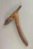 A PAPUA NEW GUINEA WOODEN AND STONE AXE with banding. 43cms high.