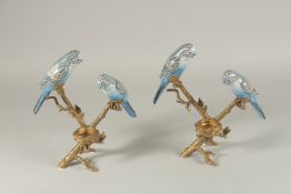A PAIR OF GILDED METAL AND PORCELAIN CANDLESTICKS each with two birds. 26cms high.