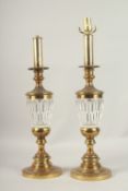 A PAIR OF BRASS AND GLASS URN SHAPED LAMPS. 60cms high.