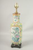A CHINESE YELLOW GROUND PORCELAIN LAMP on a wooden base. 56cms high.