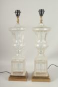 A GOOD PAIR OF GLASS URN SHAPED LAMPS on metal bases. 60cms high.