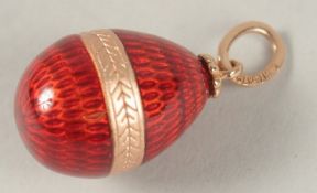 A RUSSIAN 14CT GOLD RED ENAMEL EGG PENDANT.