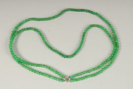 A DOUBLE ROW OF JADE BEADS with white gold clasp.