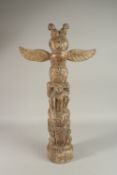 A HAND CARVED TOTEM POLE with figures and wings. 61cms high.