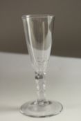 A GEORGIAN WINE GLASS with plain bowl and facet cut stem. 18cms high.