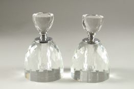 A PAIR OF CRYSTAL CUT CIRCULAR SCENT BOTTLES.