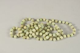 A LONG STRING OF JADE BEADS. 130cms long.