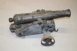AN 18TH CENTURY CONTINENTAL CAST IRON CANNON, on a wooden wrought iron carriage, with cast iron