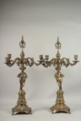 A PAIR OF BRONZE CHERUB FOUR-BRANCH CANDELABRA.