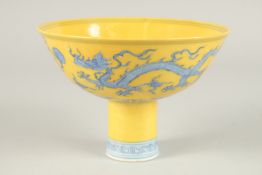 A CHINESE YELLOW GROUND BLUE AND WHITE DRAGON STEM CUPS. 15cms diameter.
