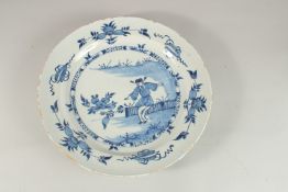 A GOOD 18TH CENTURY TIN GLAZE BLUE AND WHITE CHARGER decorated with a Chinaman, fence, flowers and