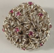 A PLATINUM PIERCED CIRCULAR DOME SHAPED BROOCH set with rubies, with unusual clasp. 3.5cms