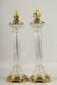 A PAIR OF 1920'S BRASS AND GLASS COLUMN LAMPS. 60cms high.
