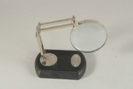 A CHROME MAGNIFYING GLASS on a stand.