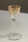 A GOOD GEORGIAN WINE GLASS, the bowl decorated in gilt with fruiting vines and facet cut stem. 14cms