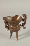 A CHINESE BRONZE JUI CUP on three legs. 14cms high.