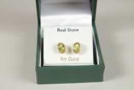 A PAIR OF 9CT GOLD OVAL PERIDOT EARRINGS.