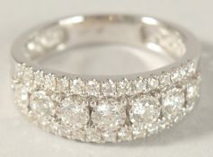 AN 18CT WHITE GOLD AND DIAMOND HALF HOOP RING.
