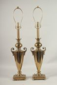 A PAIR OF BRASS TWO-HANDLED URN SHAPED LAMPS. 60cms high.