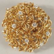 AN 18CT GOLD PIERCED CIRCULAR DOME SHAPED BROOCH set with diamonds, with unusual clasp. 3.5cms