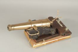 AN EARLY 19TH CENTURY BRONZE CANNON. 28cms long on a wooden stand.