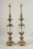 A PAIR OF BRASS AND GLASS COLUMN LAMPS with pineapple finials. 70cms high.