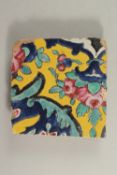 AN EARLY 19TH CENTURY PERSIAN YELLOW GLAZED POTTERY TILE, 18cm x 18cm.