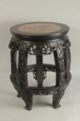 A CHINESE RED MARBLE INSET HARDWOOD VASE STAND, of barrel form with carved and pierced frieze on