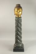A GILDED STONE BUDDHA HEAD, standing on a spiraled marble column (with inset metal rod to support