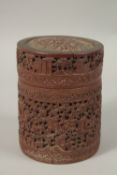 A CHINESE FINELY CARVED BAMBOO LIDDED BRUSH POT, with a continuous village scene, 15cm high.