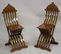 A PAIR OF MOROCCAN MARQUETRY INLAID WOODEN FOLDING CHAIRS.