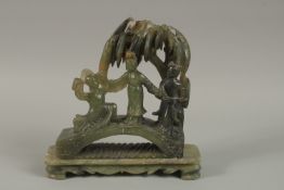 A LARGE CHINESE CARVED JADE GROUP, depicting three figures on a bridge beneath a tree, together with