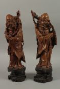 A VERY FINE PAIR OF CHINESE CARVED HARDWOOD FIGURES, with inset bead eyes, 45cm high.