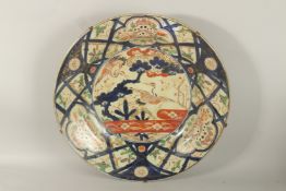 A VERY LARGE 19TH CENTURY JAPANESE IMARI PORCELAIN CHARGER, painted with a central panel of cranes