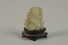 A CHINESE MINIATURE JADE CARVING OF AN IMMORTAL WITH ANIMAL, on a wooden stand, jade 3.5cm high.