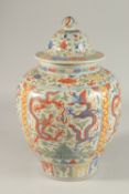 A CHINESE WUCAI PORCELAIN GINGER JAR AND COVER, painted with dragons and floral motifs, 35cm high.