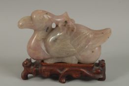 A LARGE CHINESE CARVED ROSE QUARTZ FIGURE OF A BIRD, on a carved hardwood stand, quartz 20cm long.