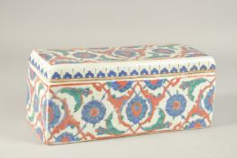 A TURKISH IZNIK GLAZED POTTERY RECTANGLAR LIDDED BOX, 28cm long.