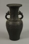 A CHINESE BRONZE TWIN HANDLE VASE, with archaic designs and dragon head handles, character mark to
