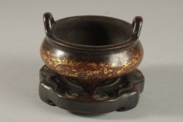 A CHINESE GOLD SPLASH BRONZE TWIN HANDLE CENSER, on hardwood stand, with six-character mark to base,
