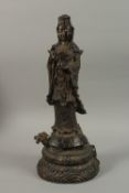 A FINE AND LARGE CHINESE BRONZE FIGURE OF GUANYIN, stood upon a mythical turtle on a circular