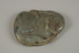 A LARGE CHINESE CARVED JADE PEBBLE, with two mythical beasts, 15cm x 11cm.