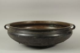 A LARGE 19TH CENTURY INDIAN OR SOUTH EAST ASIAN BRONZE TWIN HANDLE URLI, 59cm diameter. *Note: a