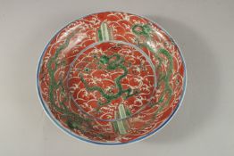 A CHINESE CORAL RED GROUND PORCELAIN DISH, with painted enamels depicting green dragons on