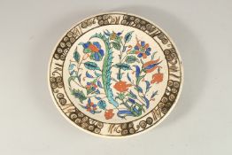 AN IZNIK GLAZED POTTERY PLATE, painted with floral spray, 25cm diameter.
