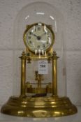A brass anniversary style clock under a glass dome.