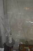 A set of five large conical shaped wine glasses with clear air twist stems.