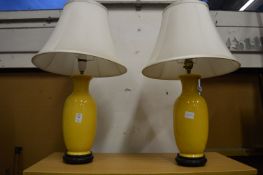 A pair of Chinese style yellow table lamps (one damaged).