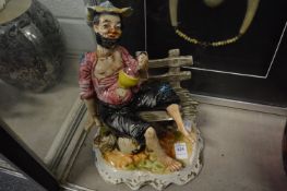 Capodimonte style figure of a tramp on a bench.