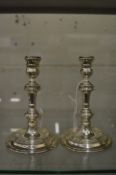 A pair of circular silver candlesticks.